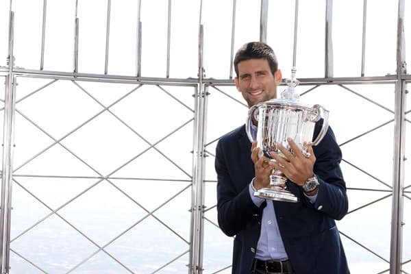 US Open Champion, Novak Djokovic of Serbia, poses with the championship trophy as he visits The Empire State Building on September 13, 2011 in New York City.