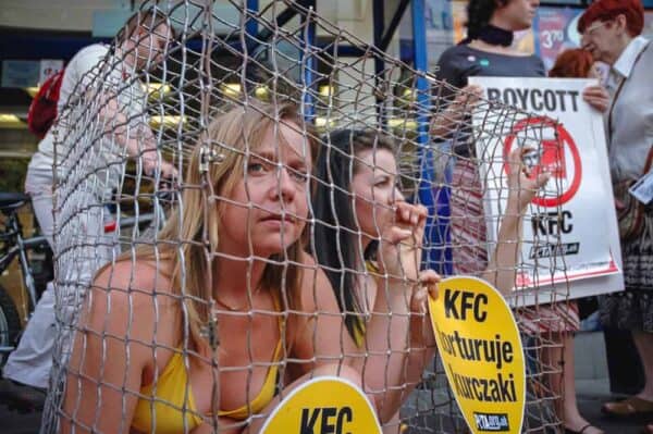 Animal activists Jodi Ruckley (left) and Karolina Kostrzzewa-Colwill (right) in a cage during a protest for PETA's Campaign Against KFC in front of a KFC restaurant in Warsaw, Poland.